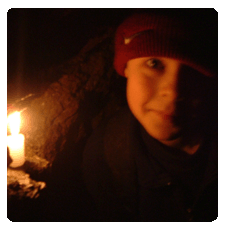 image of a child with a candle looking at the camera inside a mine