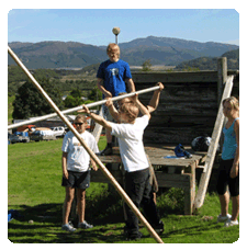 image of children building a structure outdoors with planks of wood