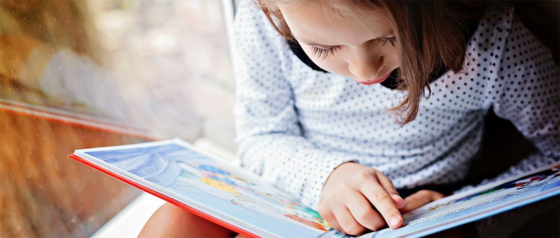 A photo of a child reading a book