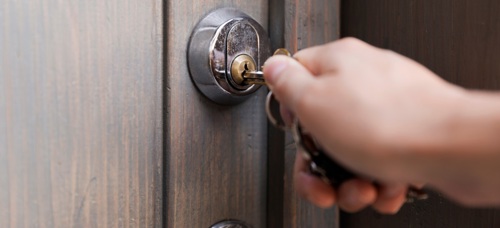 A photograph showing a key being inserted into a lock on a front door