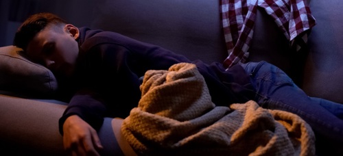 A youth sleeping on a sofa