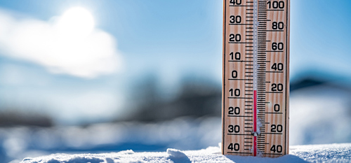 Thermometer on snow shows low temperatures in celsius.