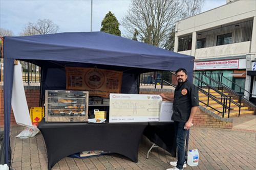 A photo showing Idris Kaji at his market stall in Russell Square, Madeley