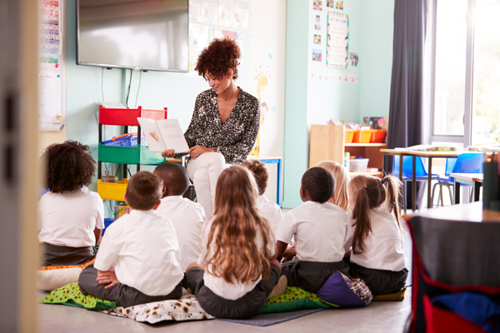 Picture of a teacher reading to primary school children