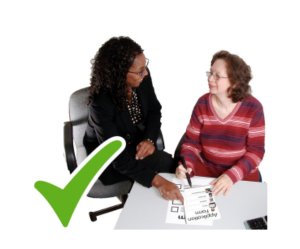 Two people sitting at a desk reviewing some paperwork