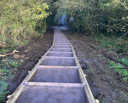 A photo showing the replacement of a public footpath with a sloped elevation, showing the wooden frames used for each step.