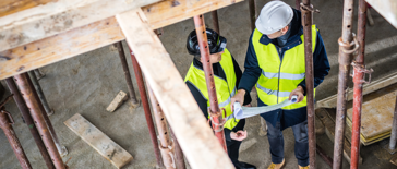 A photo of two contractors reviewing site plans on a building site