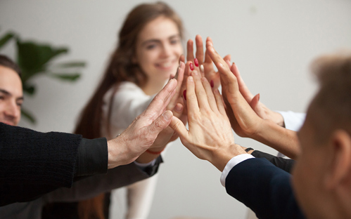 Motivated successful business team giving high five