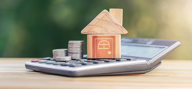 House is placed on the calculator and coin is on the calculator. planning savings money of coins to buy a home concept for property ladder, mortgage and real estate investment saving for a buy house.