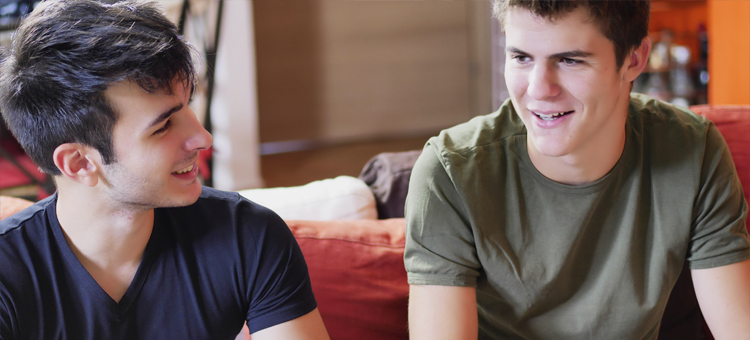 Image of two teenagers sat on a sofa