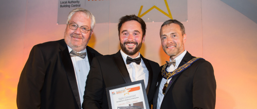 A photo of three men with an award
