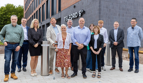 A group photo of Council cabinet members and colleagues from Telford College standing outside Telford 6th building.