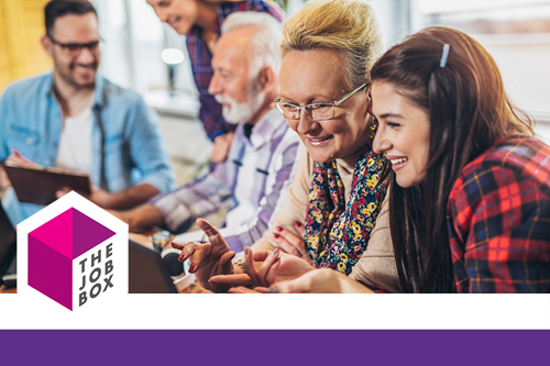 Picture of a group of young volunteers helping senior people on the computer.
