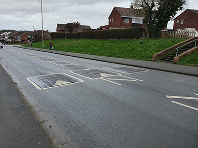 A photograph of a speed cushions on a residential road