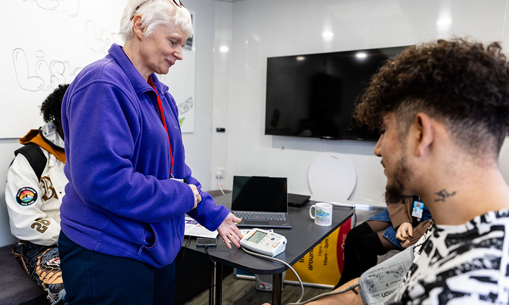 A photograph showing a healthcare professional measuring a person’s blood pressure.