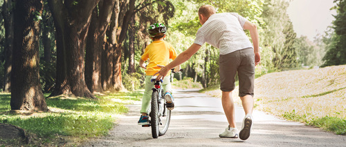 A father teaching his child how to ride a bicycle