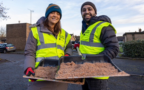 Picture of two happy snow wardens volunteering to help their community in the winter.