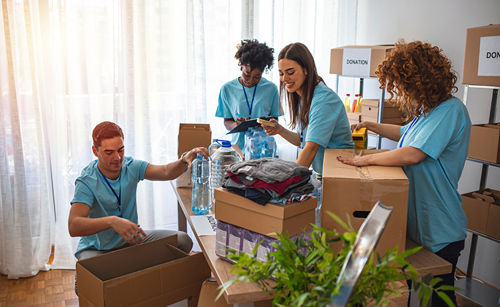Photograph of volunteers working at a food and clothes bank, packing up food parcels